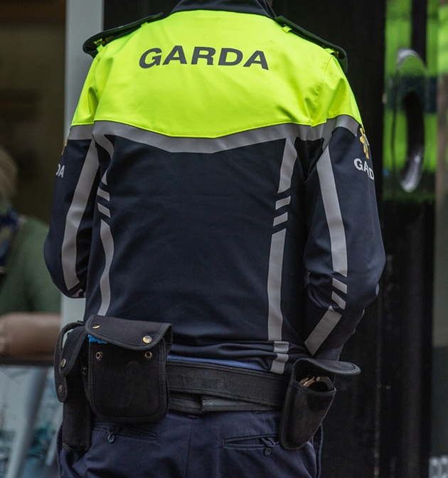 Ofițer de la Garda din Irlanda, stând cu spatele la aparatul de fotografiat