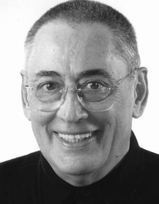 Imagine alb-negru cu portretul lui Horia Moculescu zâmbitor, îmbrăcat în negru, cu ochelari de vedere la ochi