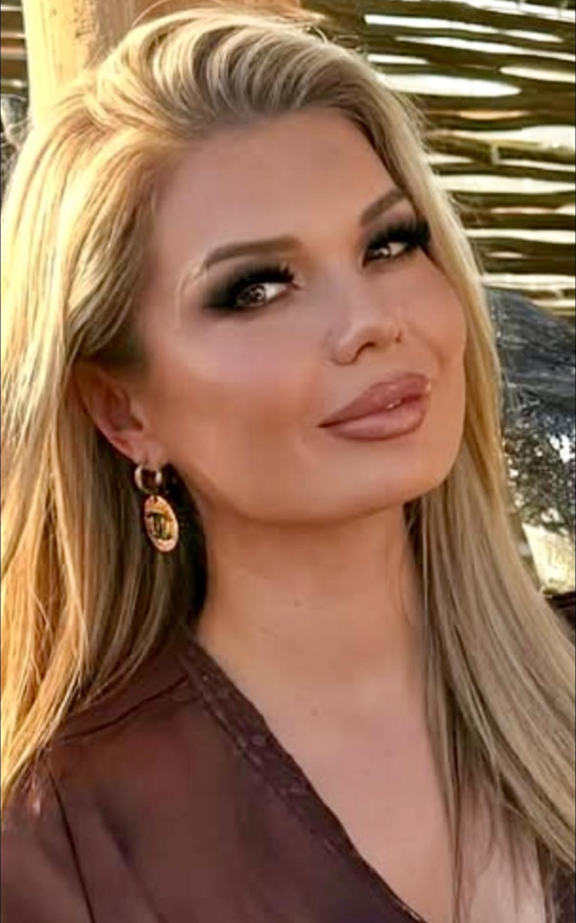 Lydia Williams zâmbitoare, îmbrăcată într-o bluză maro, purtând în urechi cercei mari aurii