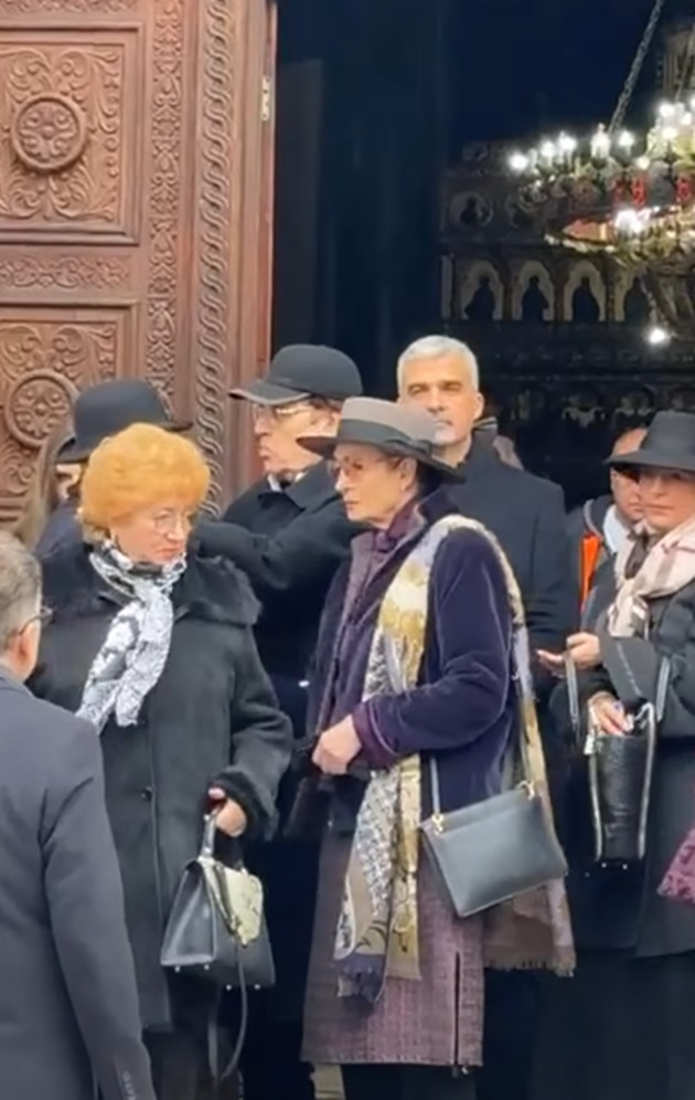 Angela Similea la înmormântarea lui Horia Moculescu, pe treptele capelei din Cimitirul Bellu, acolo unde a fost depus sicriul cu trupul compozitorului, îmbrăcată în nuanțe de mov, cu pălărie pe cap și geantă pe umăr