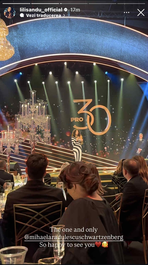 Mihaela Rădulescu la filmările unei emisiuni de la ProTV, stând pe scenă în fața colegilor ei din televiziune și vorbind la microfon