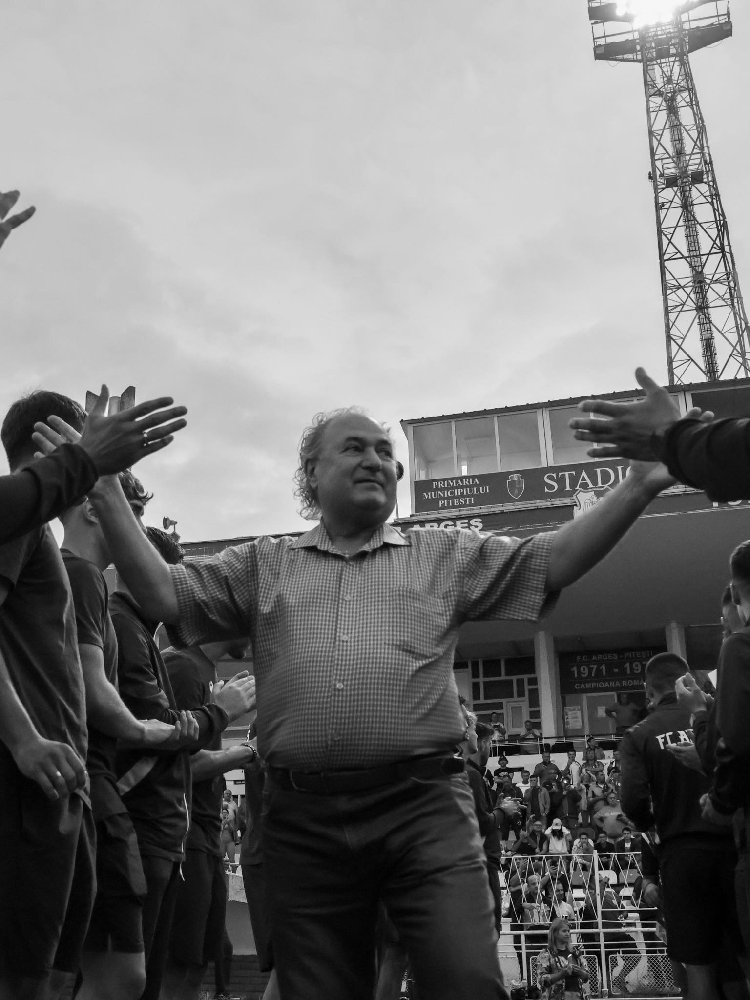 Imagine alb-negru cu Doru Toma între fotbaliști, dând mâna cu ei