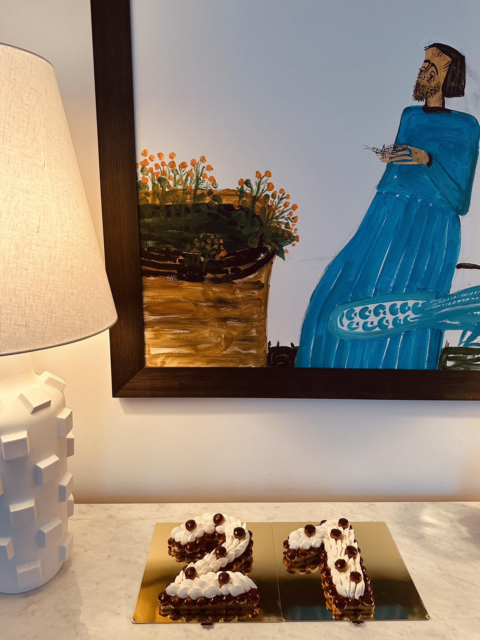 Tortul gemenelor Danei Budeanu, din ziua în care au împlinit 21 de ani, realizat în formă de număr, așezat pe o masă în casa creatoarei de modă, lângă o veioză și un tablou abstract.