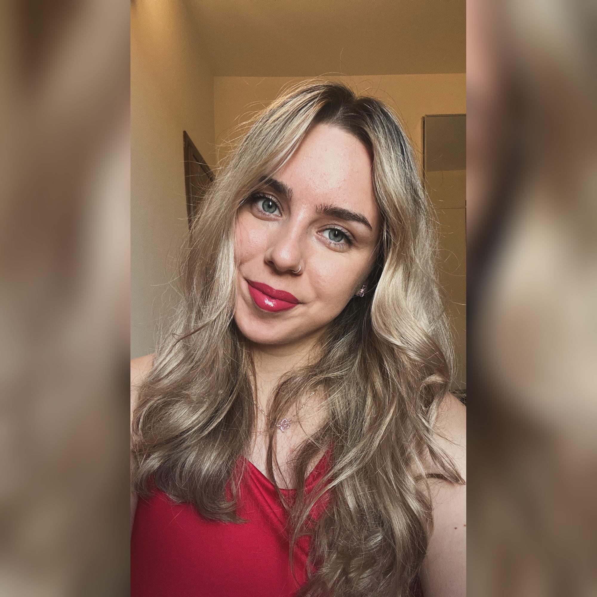 Georgiana Buloi într-un maiou roșu, cu părul ondulat și cu ruj lucios pe buze