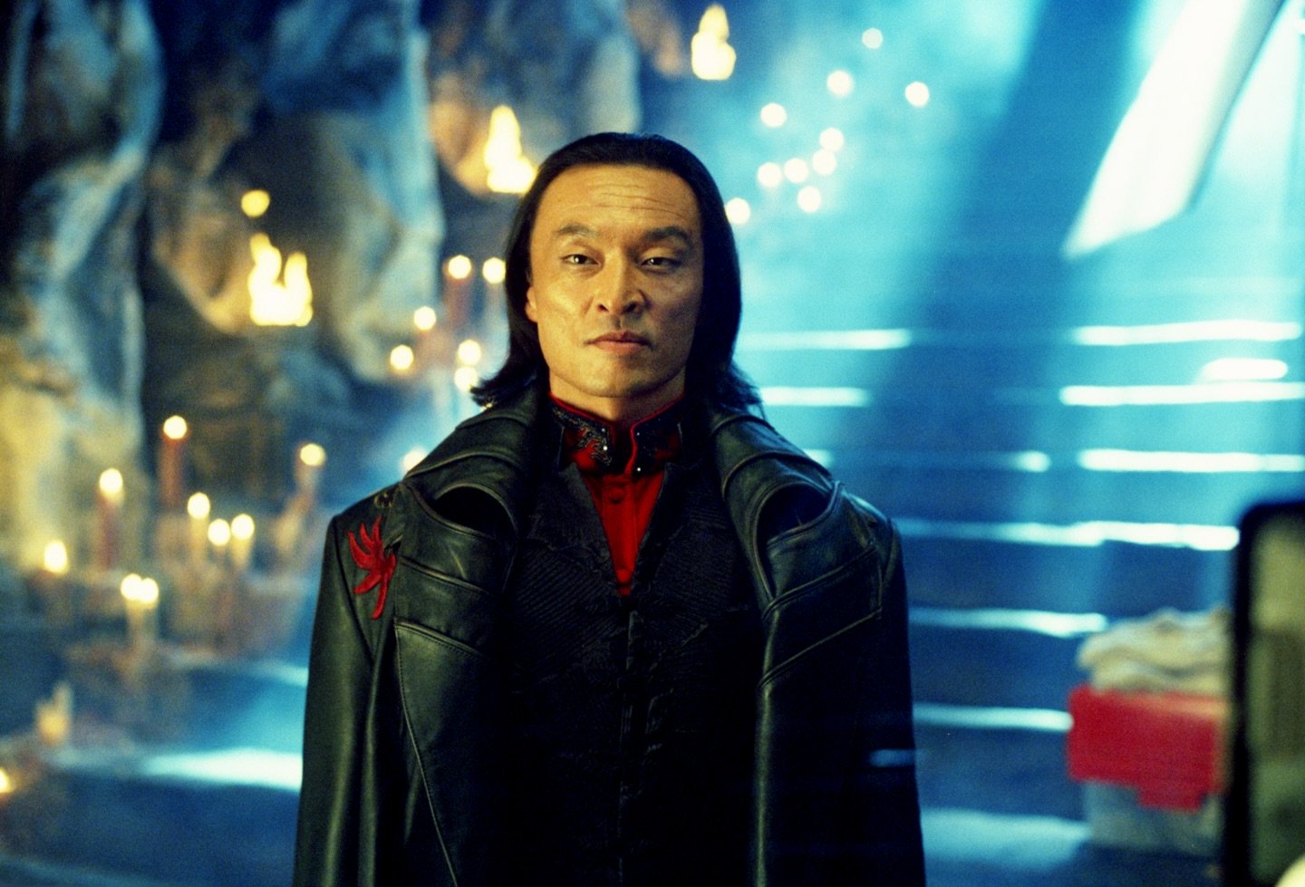 Cary-Hiroyuki Tagawa în haină lungă de piele, stând în fața unor trepte luminate
