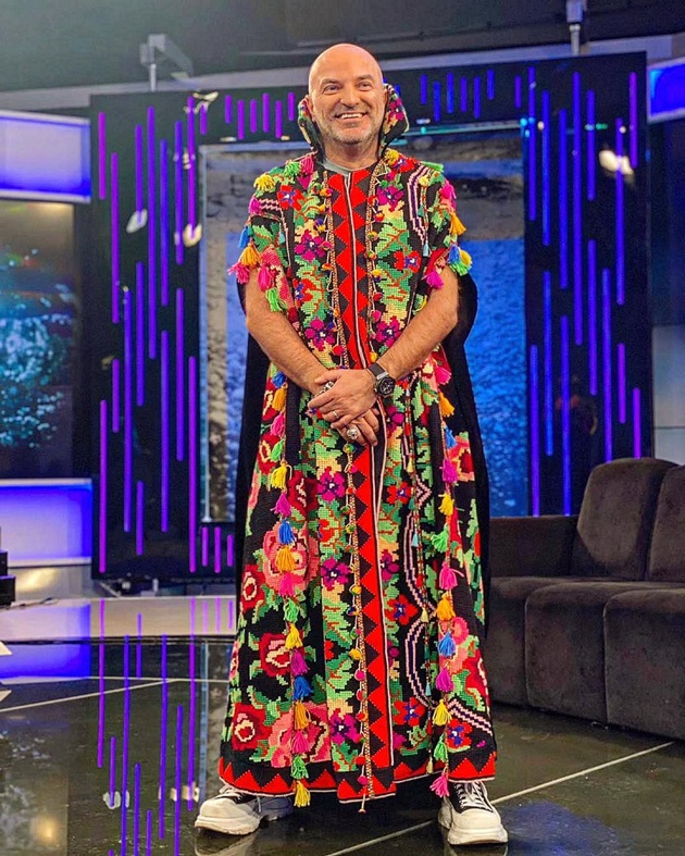 Dan Capatos în platoul emisiunii „Un show păcătos” de la Antena Stars, într-o vestă lungă cu motive tradiționale
