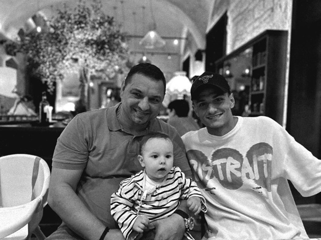 Ionel Ganea fericit, într-un restaurant, stând lângă fiul său cel mare, George Ganea, și ținându-l în brațe pe mezinul Alexandru