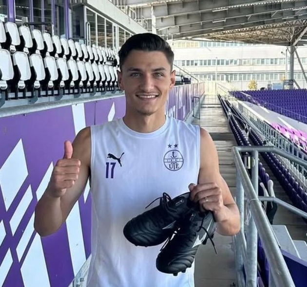 George Ganea, fiul cel mare al lui Ionel Ganea, în tribune, în echipament sportiv, ținându-și încălțările în mână