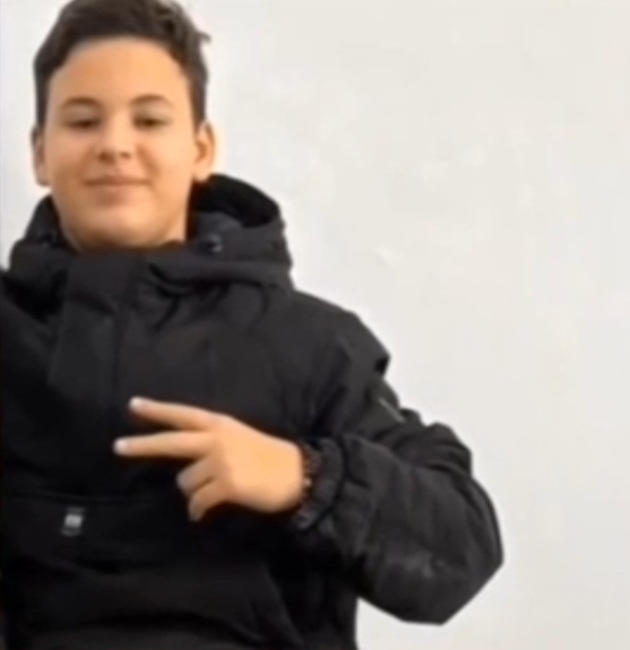 Greblă Eduard Adrian z&acirc;mbitor, &icirc;ntr-o geacă neagră, făc&acirc;nd semnul &bdquo;v&rdquo;, semnul victoriei cu degetele