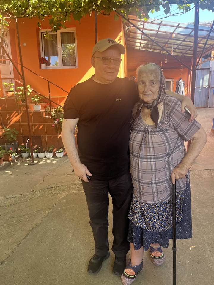 Georgică Cornu țin&acirc;nd-o de g&acirc;t pe mama sa, &icirc;n curtea casei ei, &icirc;n timp ce aceasta se sprijină &icirc;n baston