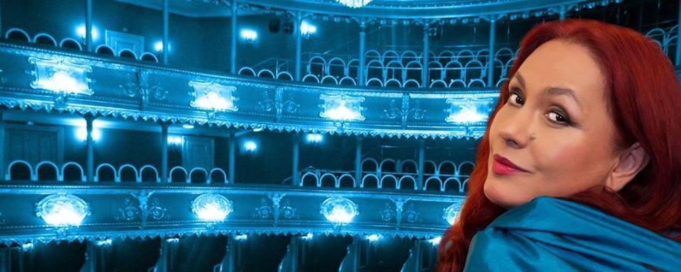 Soprana Anda-Louise Bogza &icirc;mbrăcată &icirc;n albastru, asortată cu lumina difuză din sala de operă &icirc;n care s-a fotografiat