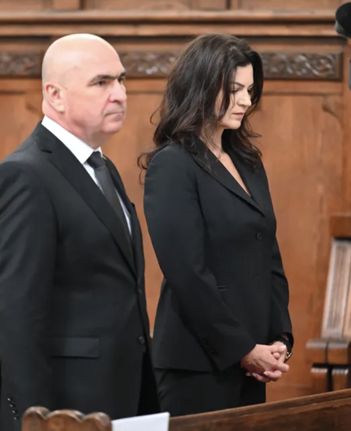 Ilie Bolojan și Ioana F&acirc;șie, am&acirc;ndoi &icirc;mbrăcați &icirc;n negru, st&acirc;nd unul l&acirc;ngă celălalt la un eveniment, &icirc;n timp ce el privește &icirc;n față, iar ea se uită &icirc;n jos, cu m&acirc;inile &icirc;mpreunate