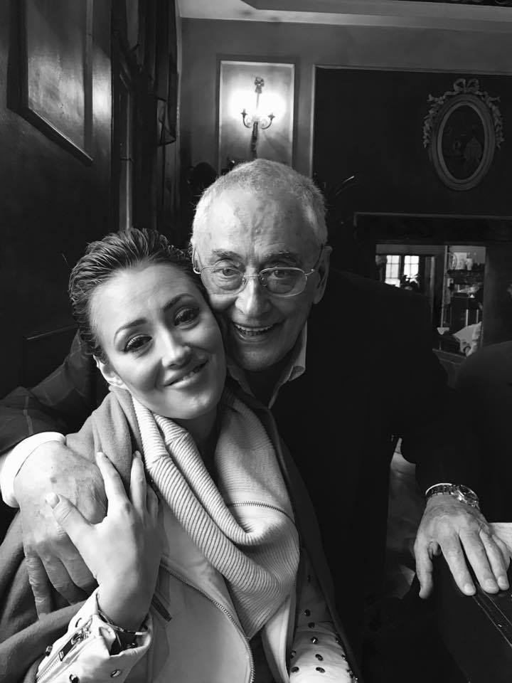 Imagine alb-negru cu Horia Moculescu z&acirc;mbitor, &icirc;mbrățiș&acirc;nd-o pe fiica sa, Nidia Moculescu, &icirc;n timp ce aceasta stătea pe un scaun, &icirc;mbrăcată &icirc;ntr-un pulover cu guler voluminos și cu geacă albă de piele