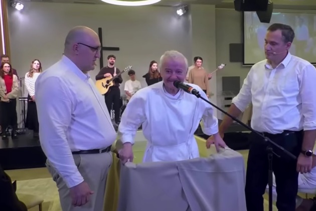 Irinel Columbeanu în timpul botezului de la finalul 2025, în timp ce era scufundat în apă, după ce a decis să devină membru al comunității baptiste