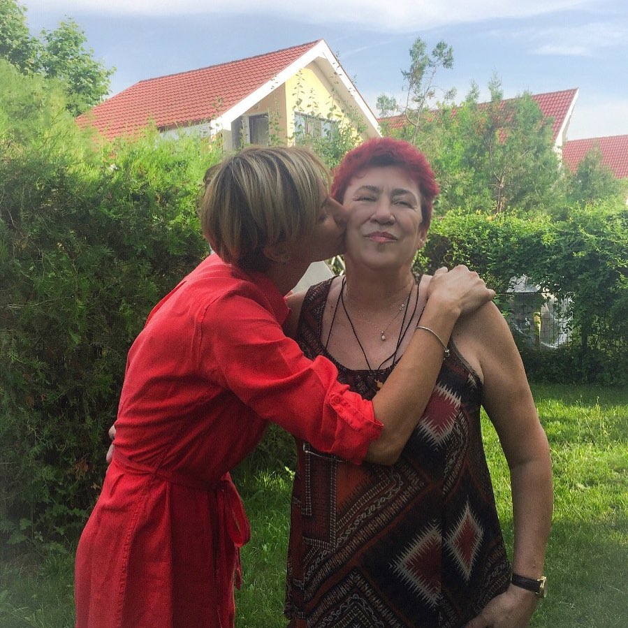Roxana&nbsp;Ciuhulescu &icirc;mbrățiș&acirc;nd-o și sărut&acirc;nd-o pe obraz pe mama ei, &icirc;n grădină, vara, &icirc;n timp ce am&acirc;ndouă erau tunse scurt și &icirc;mbrăcate &icirc;n rochii