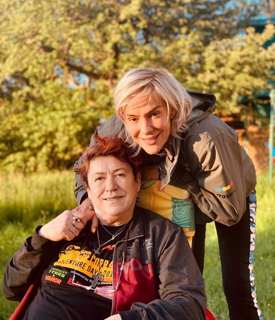 Roxana&nbsp;Ciuhulescu st&acirc;ns &icirc;n spatele mamei sale, care este așezată pe un scaun și pe care o ține de m&acirc;nă, &icirc;n timp ce z&acirc;mbesc am&acirc;ndouă cu privirea spre camera foto