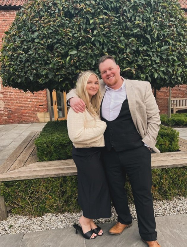 Isobella și soțul ei, Paul Knight, &icirc;mbrăcați elegant, fotografiindu-se &icirc;mpreună la un eveniment