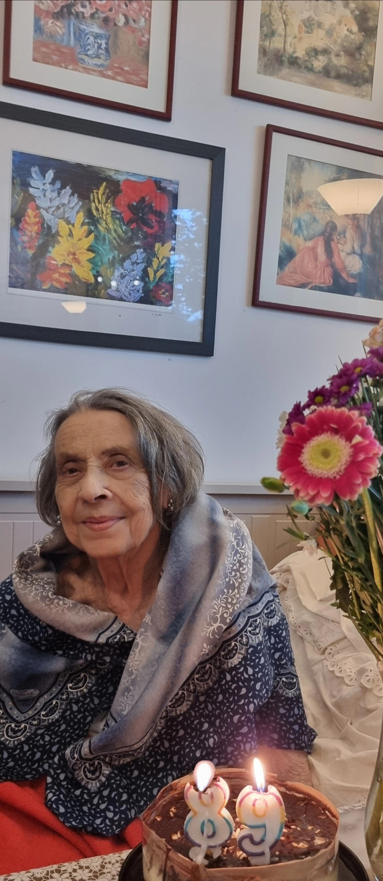 Mama Biancăi Brad z&acirc;mbitoare, &icirc;n ziua &icirc;n care a &icirc;mplinit 89 de ani, st&acirc;nd pe marginea patului, cu tortul aniversar l&acirc;ngă ea.