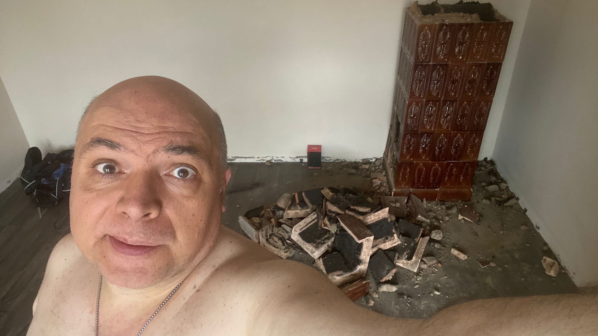 Constantin Zamfirescu făc&acirc;ndu-și un selfie la bustul gol, &icirc;n timp ce muncea la renovarea unei camere, repar&acirc;nd o sobă veche de teracotă