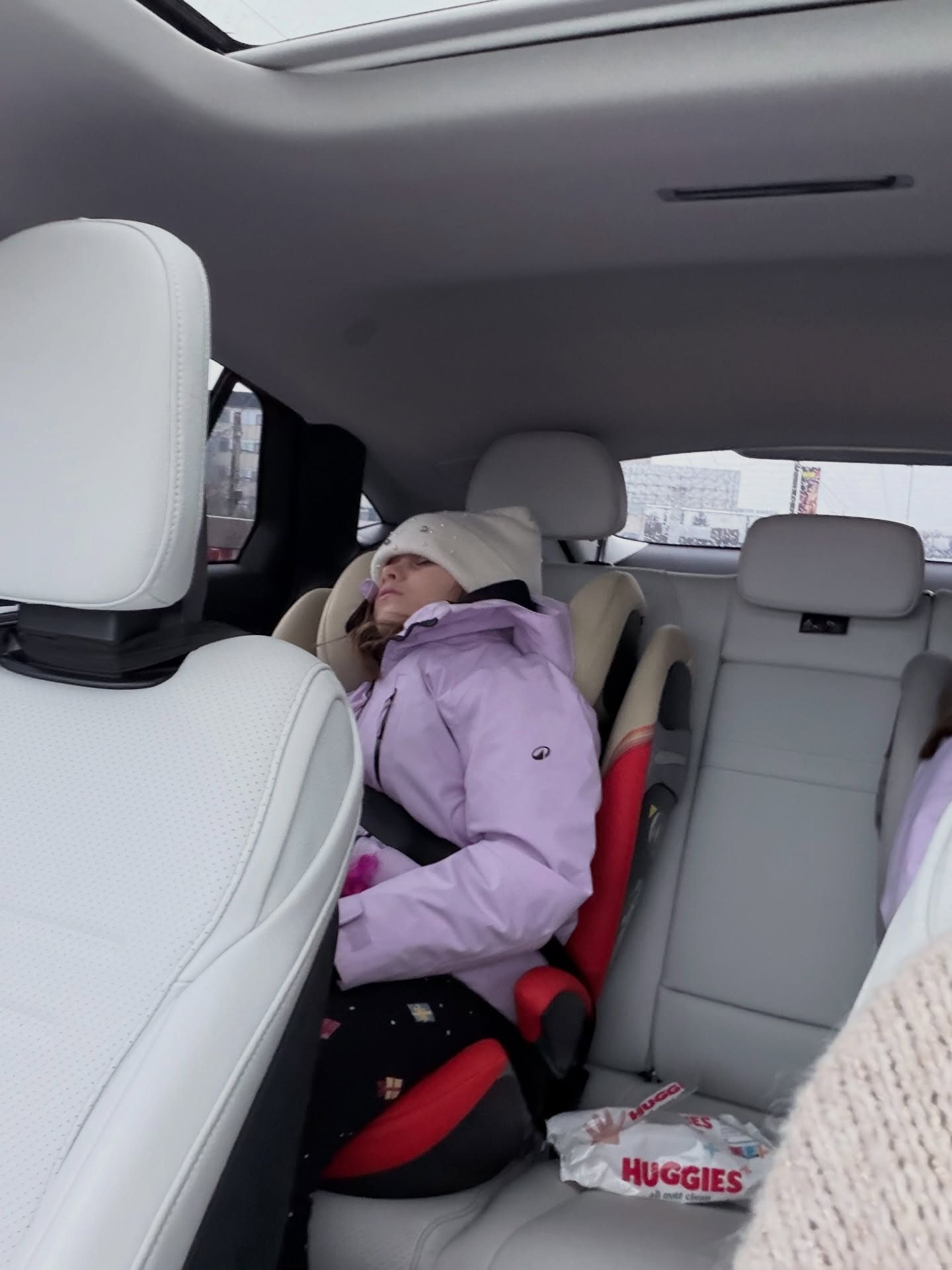 Iris, fiica cea mică a Gabrielei Cristea, dormind pe bancheta din spate a mașinii, dimineața, în drum spre școală