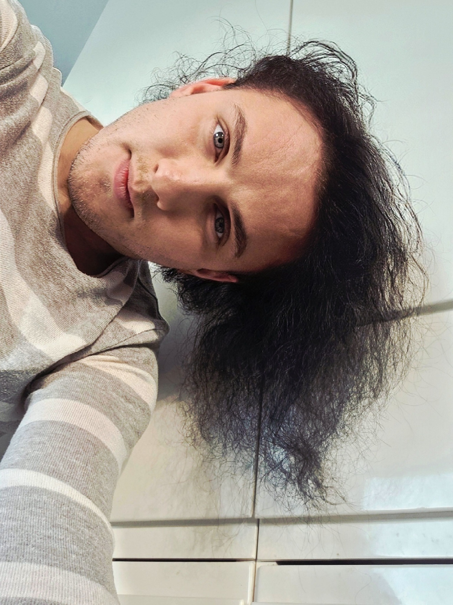 Mihai Trăistariu făc&acirc;ndu-și un selfie cu capul aplecat &icirc;ntr-o parte, &icirc;ncerc&acirc;nd să arate c&acirc;t de mult i-a crescut părul de c&acirc;nd a decis să nu se mai tundă