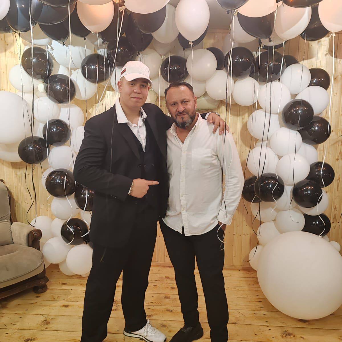 Fiul și soțul Monicăi Anghel la o petrecere, făc&acirc;ndu-și o fotografie &icirc;n fața unor baloane albe și negre, &icirc;n timp ce și ei erau &icirc;mbrăcați asortat, tot &icirc;n alb și negru