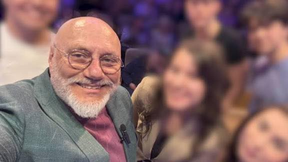 Doctorul Cristian Andrei z&acirc;mbitor, făc&acirc;ndu-și un selfie, &icirc;ntr-o bluză bordo peste care are un sacou gri &icirc;nchis