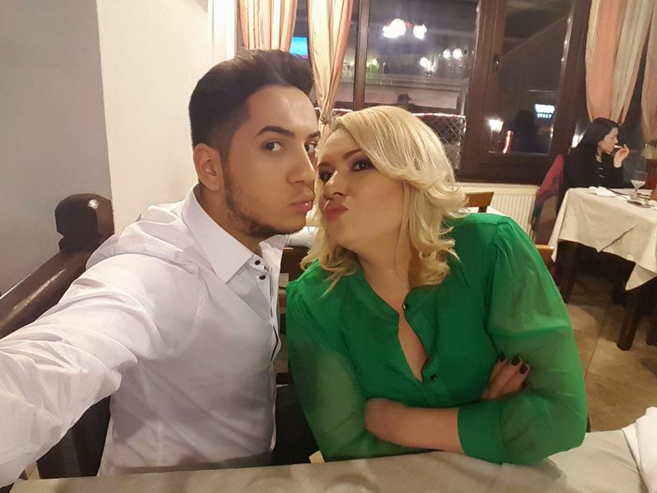 Fulgy și Viorica de la Clejani făc&acirc;ndu-și un selfie &icirc;mpreună, la masa unui restaurant, mim&acirc;nd un pupic