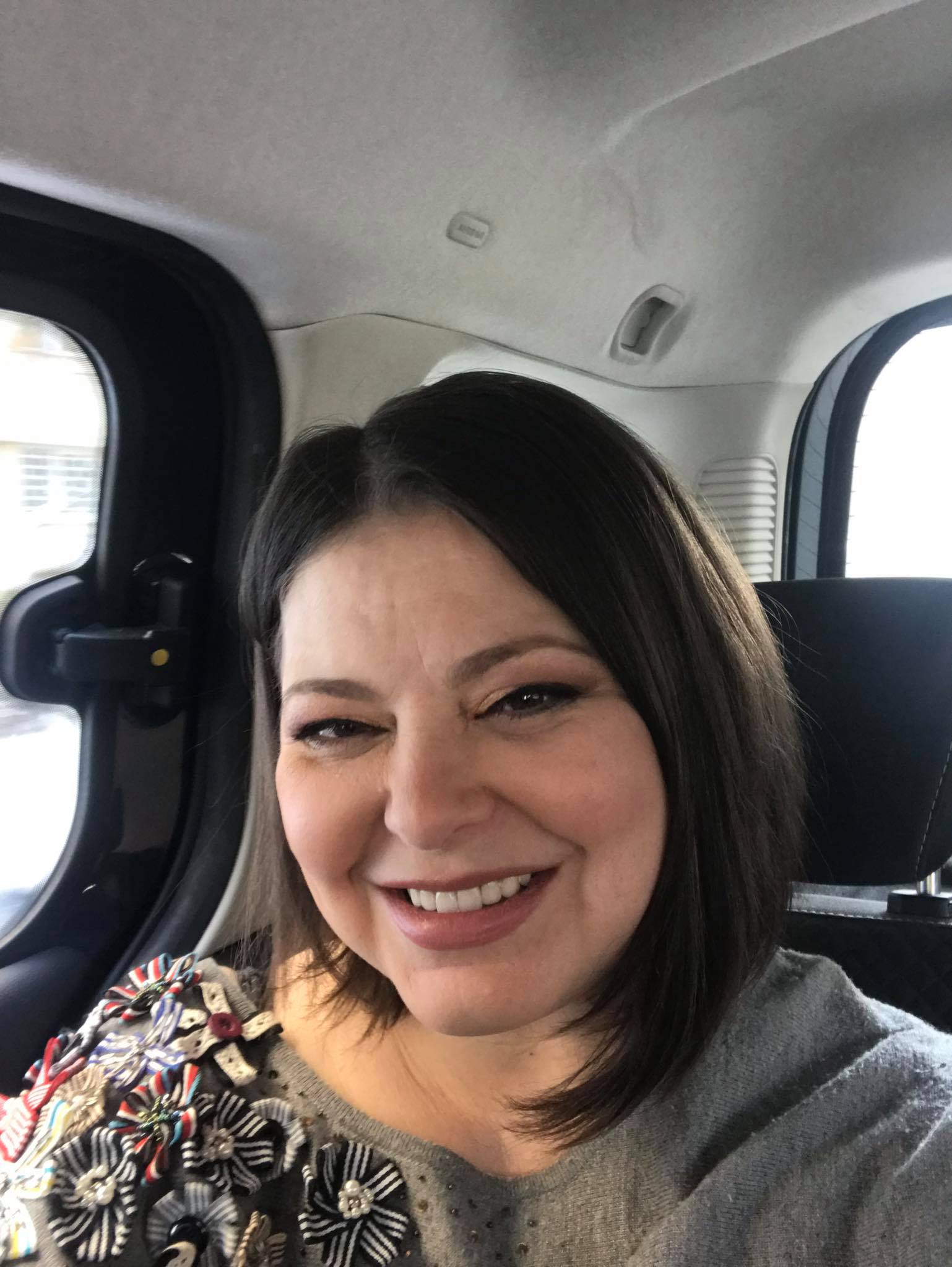 Rita Mureșan z&acirc;mbitoare, făc&acirc;ndu-și un selfie &icirc;n mașină, &icirc;n timp ce era tunsă p&acirc;nă la umăr și purta un pulover gri cu flori