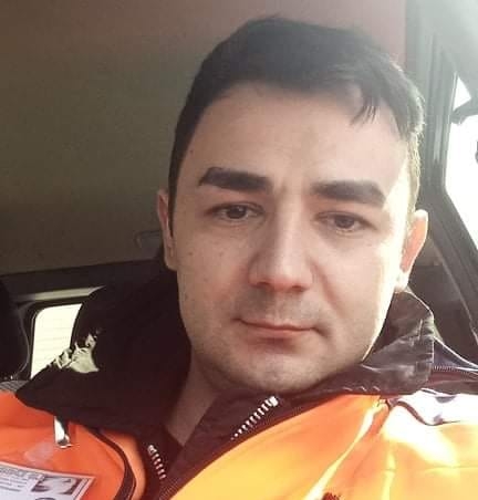 Nicu Joghiu făc&acirc;ndu-și un selfie &icirc;n timp ce see afla &icirc;n mașină, &icirc;mbrăcat &icirc;ntr-o geacă portocalie, purt&acirc;nd legitimația de serviciu &icirc;n piept