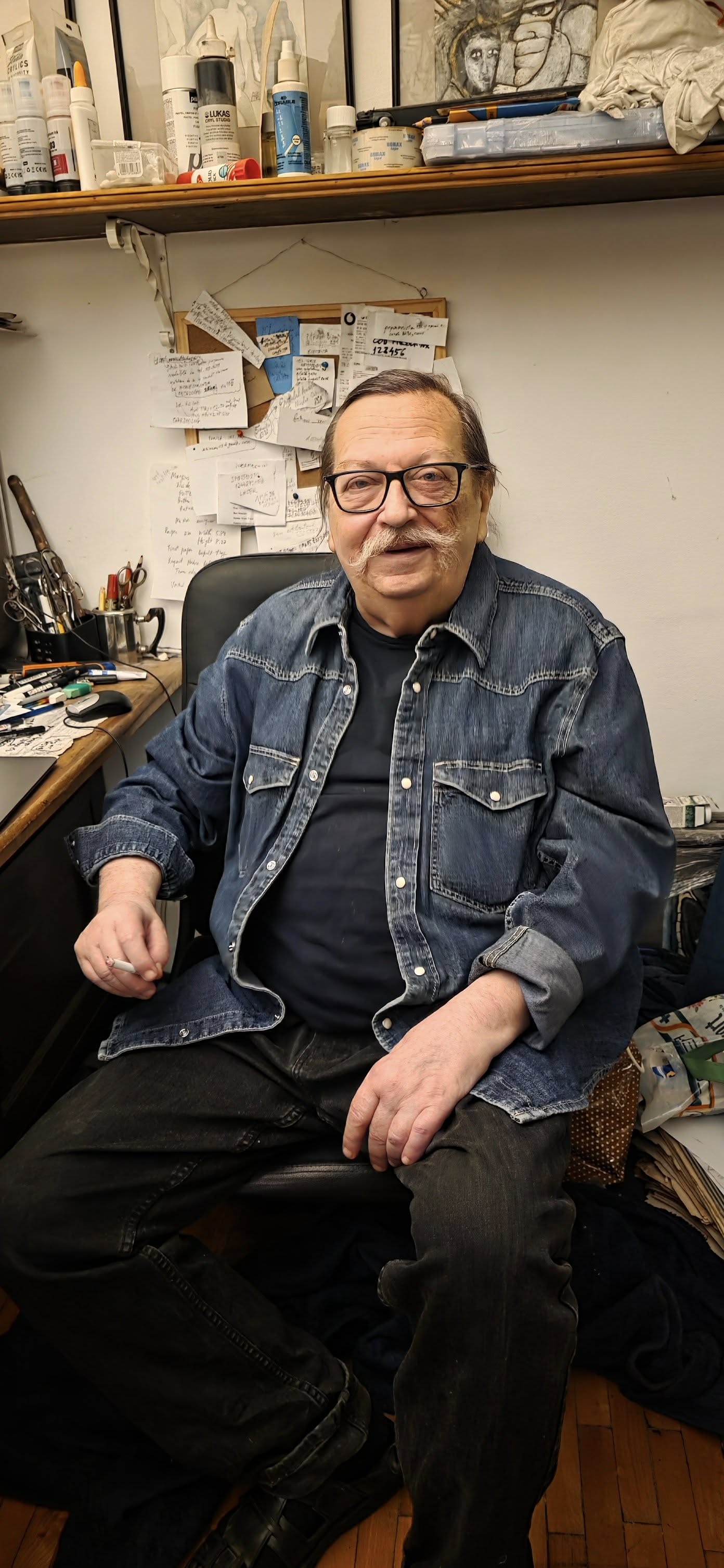 Regizorul Cristian&nbsp;Pepino așezat la un birou cu un perete cu post-its in spate