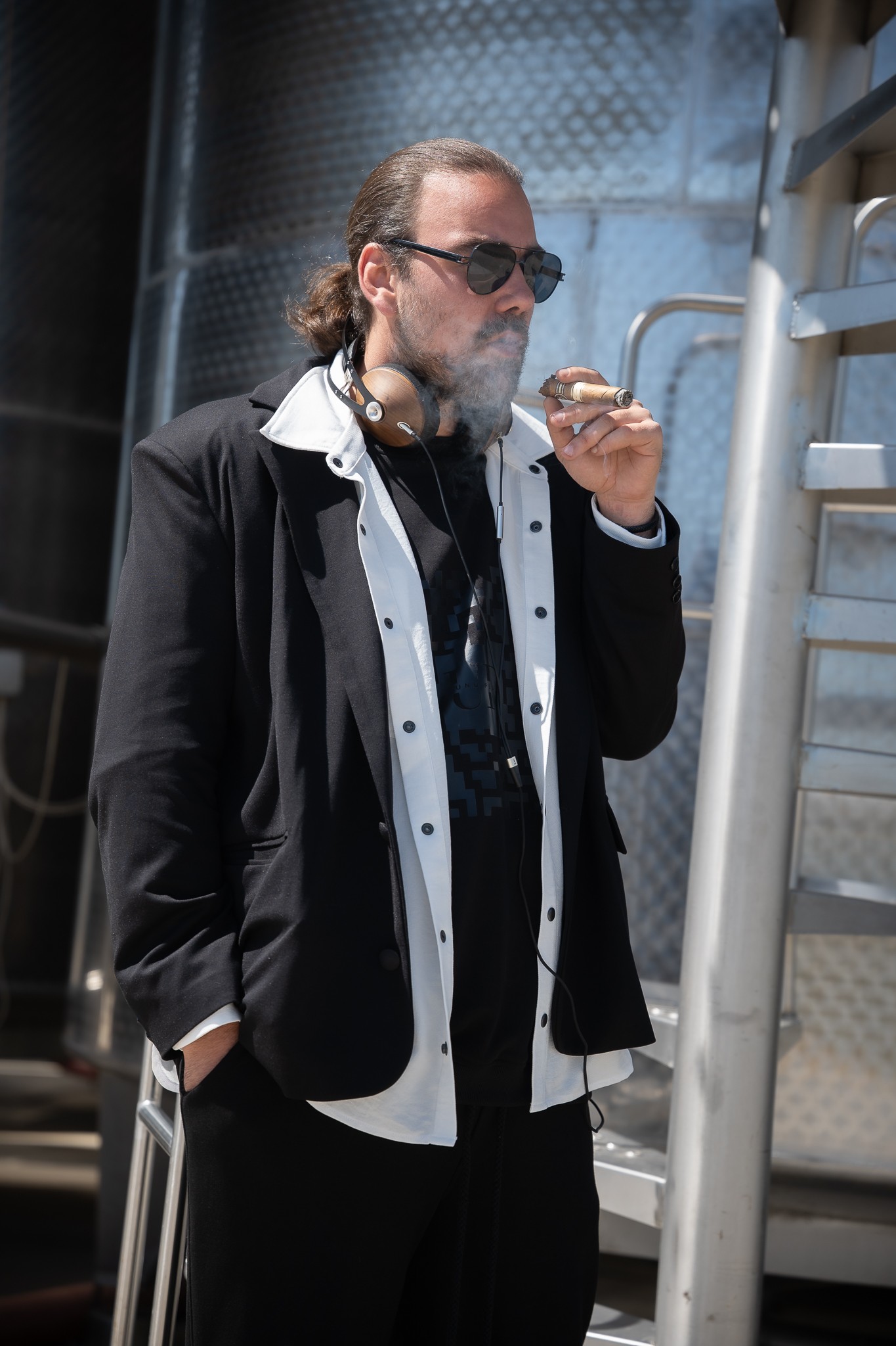 Tudor Parhon, fiul lui Carmen Tănase, &icirc;mbrăcat &icirc;n alb și negru, purt&acirc;nd ochelari la ochi, fum&acirc;nd dintr-un trabuc