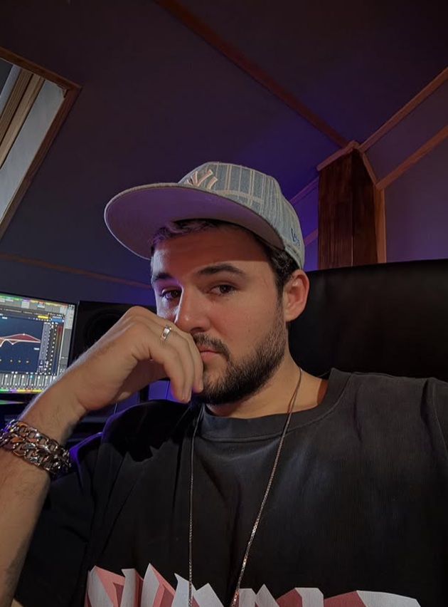 Mario Fresh făcându-și un selfie în mașină, îmbrăcat în negru, cu șapcă neagră pe cap, purtând bijuterii de mari dimensiuni