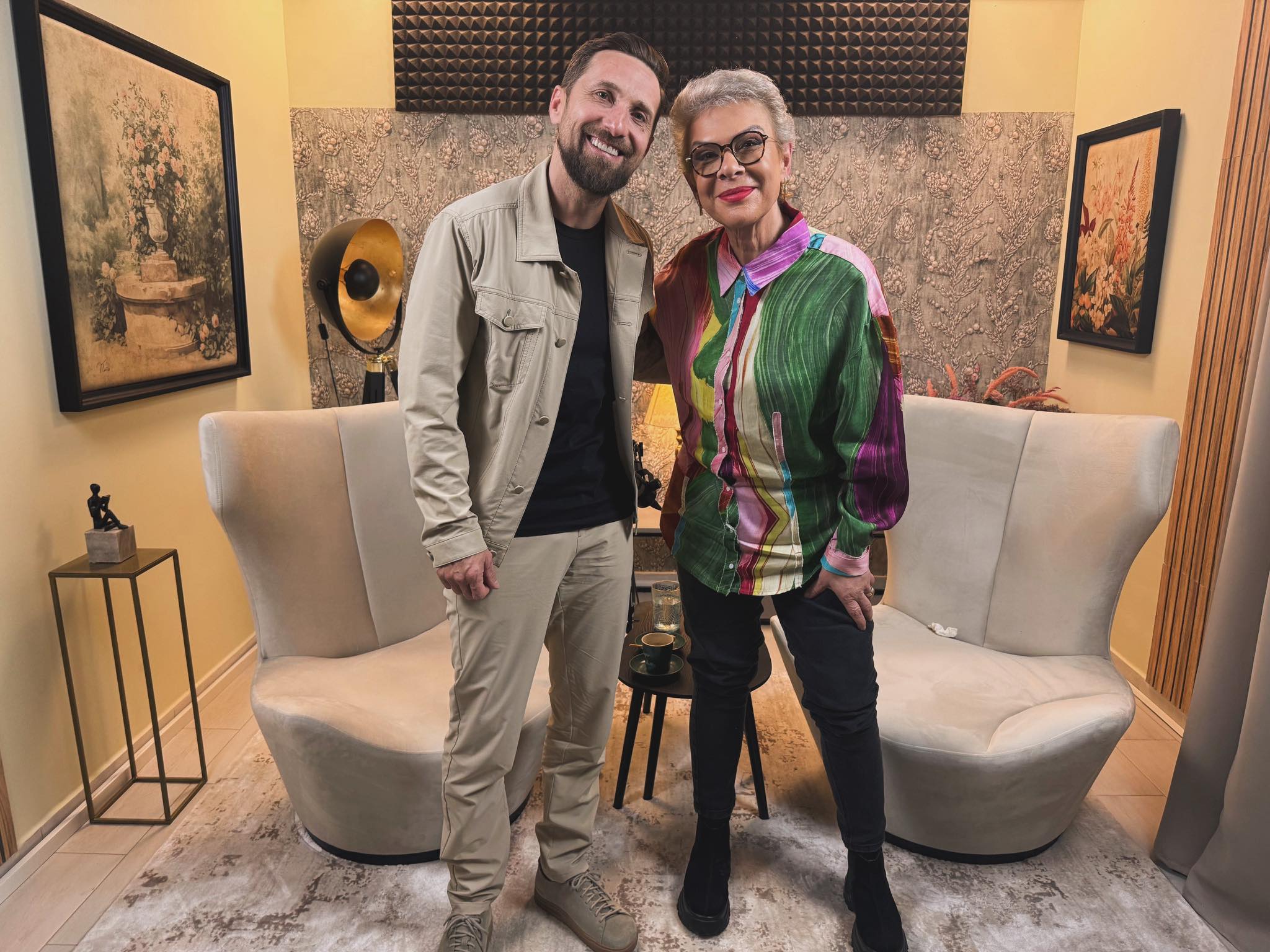 Dani Oțil și Teo Trandafir &icirc;mbrățiș&acirc;ndu-se &icirc;n platoul podcastului &bdquo;G&acirc;nd la G&acirc;nd cu Teo&rdquo;, moderat chiar de Teo Trandafir, &icirc;n timp ce stăteau am&acirc;ndoi &icirc;n fața fotoliilor pe care se stă &icirc;n timpul filmării