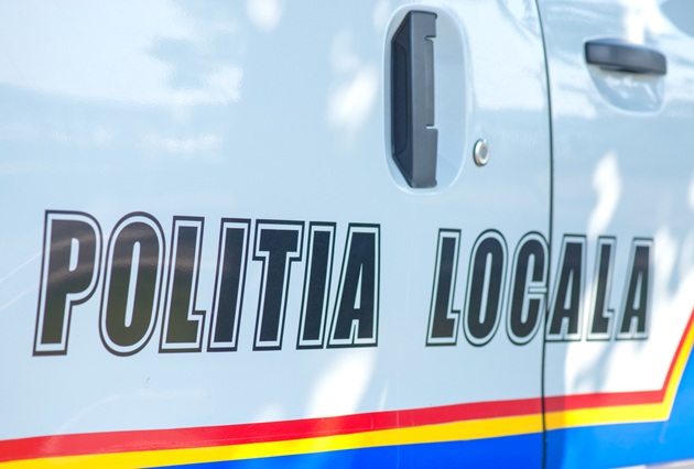Parte laterală a mașinii conduse de polițiștii de la Poliția Locală, în care se vede atât portiera din față, cât și cea din spate