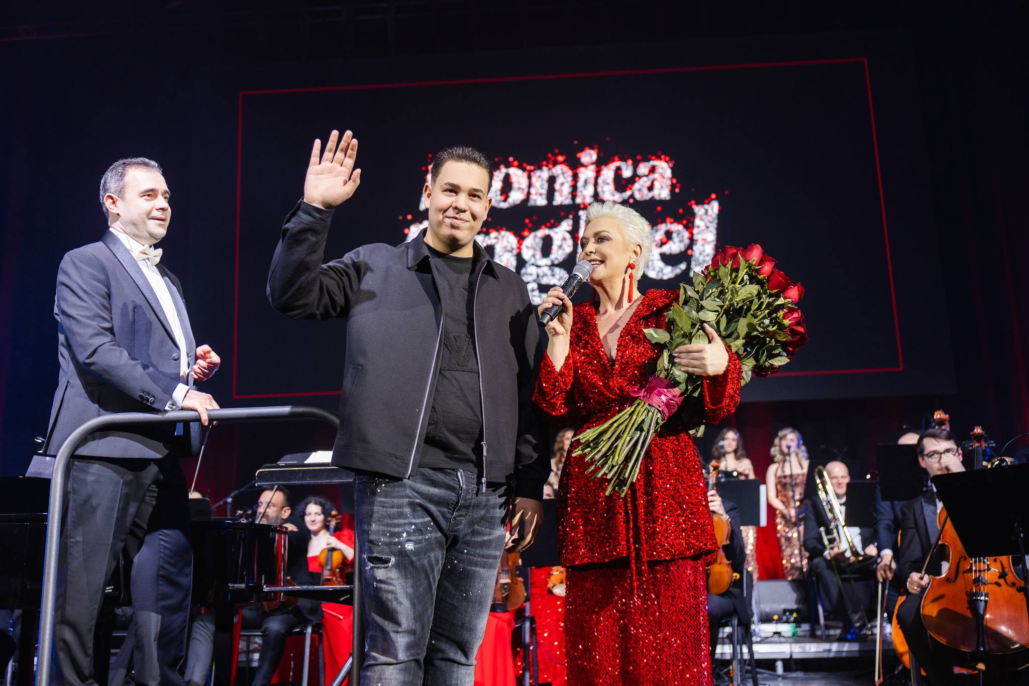 Monica Anghel pe scena de la Sala Palatului, alături de fiul său, Aviv, care i-a oferit un buchet de trandafiri roșii la concertul aniversar de 40 de ani de carieră