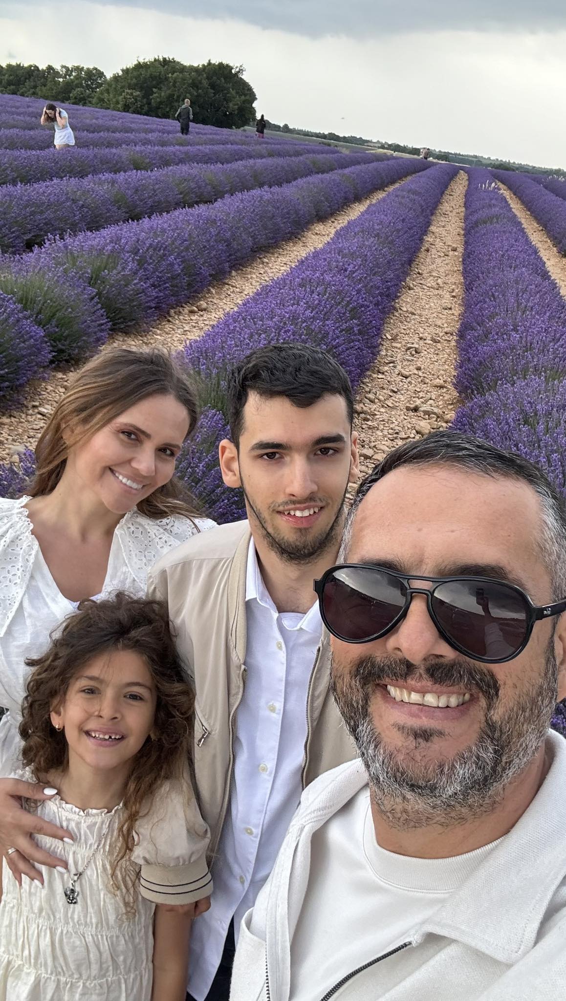 Mădălin Ionescu alături de soția sa, de fiul lui și de mezina familiei, făc&acirc;nd o fotografie &icirc;n lanul de lavandă, &icirc;n timp ce erau &icirc;mbrăcați asortat &icirc;n alb și bej