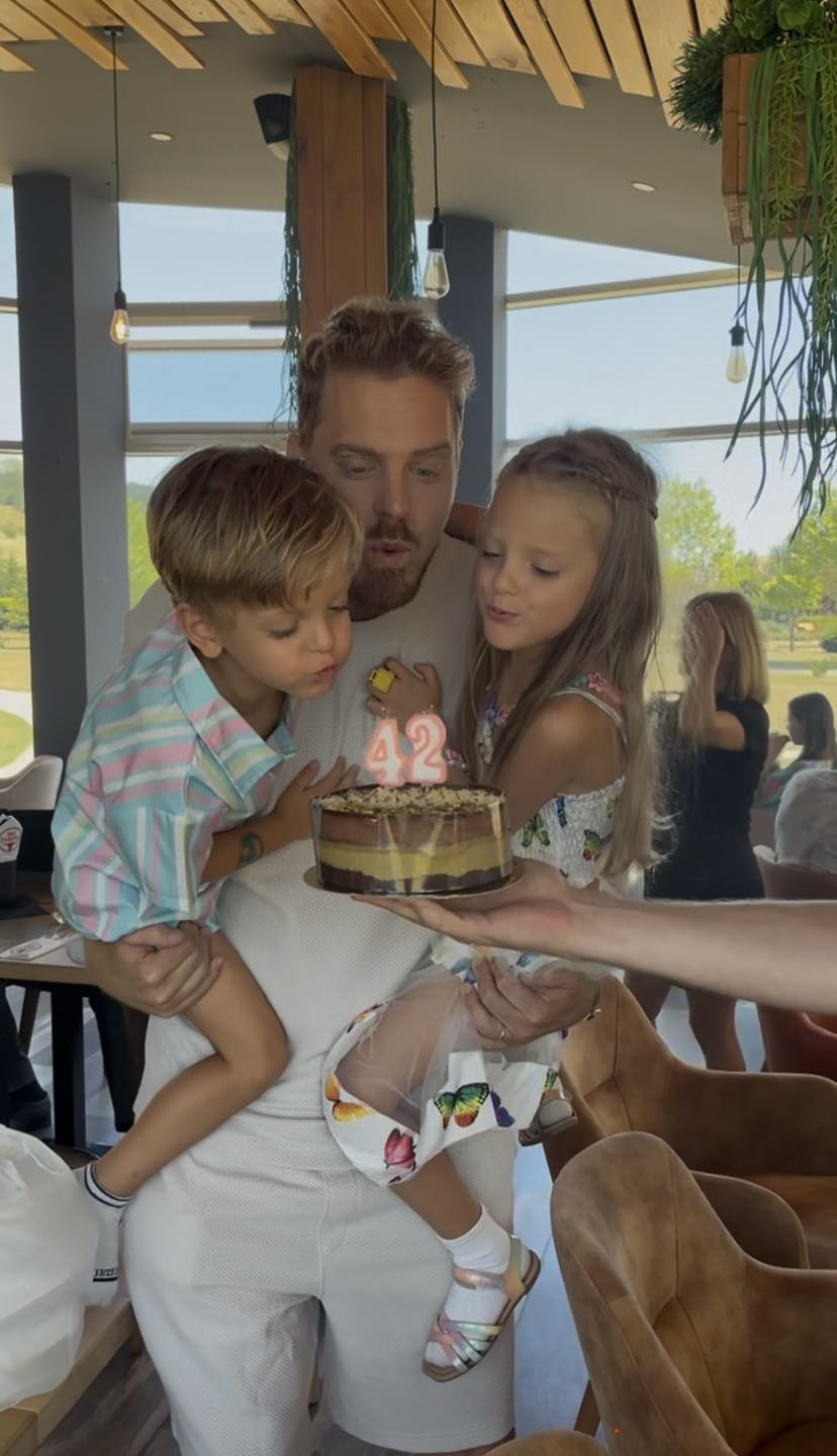 Ilan Laufer sufl&acirc;nd &icirc;n lum&acirc;nările de pe tortul de ziua lui, de c&acirc;nd a &icirc;mplinit 42 de ani, &icirc;n timp ce &icirc;i ține &icirc;n brațe pe gemenii săi,&nbsp;Davina și Nathaniel