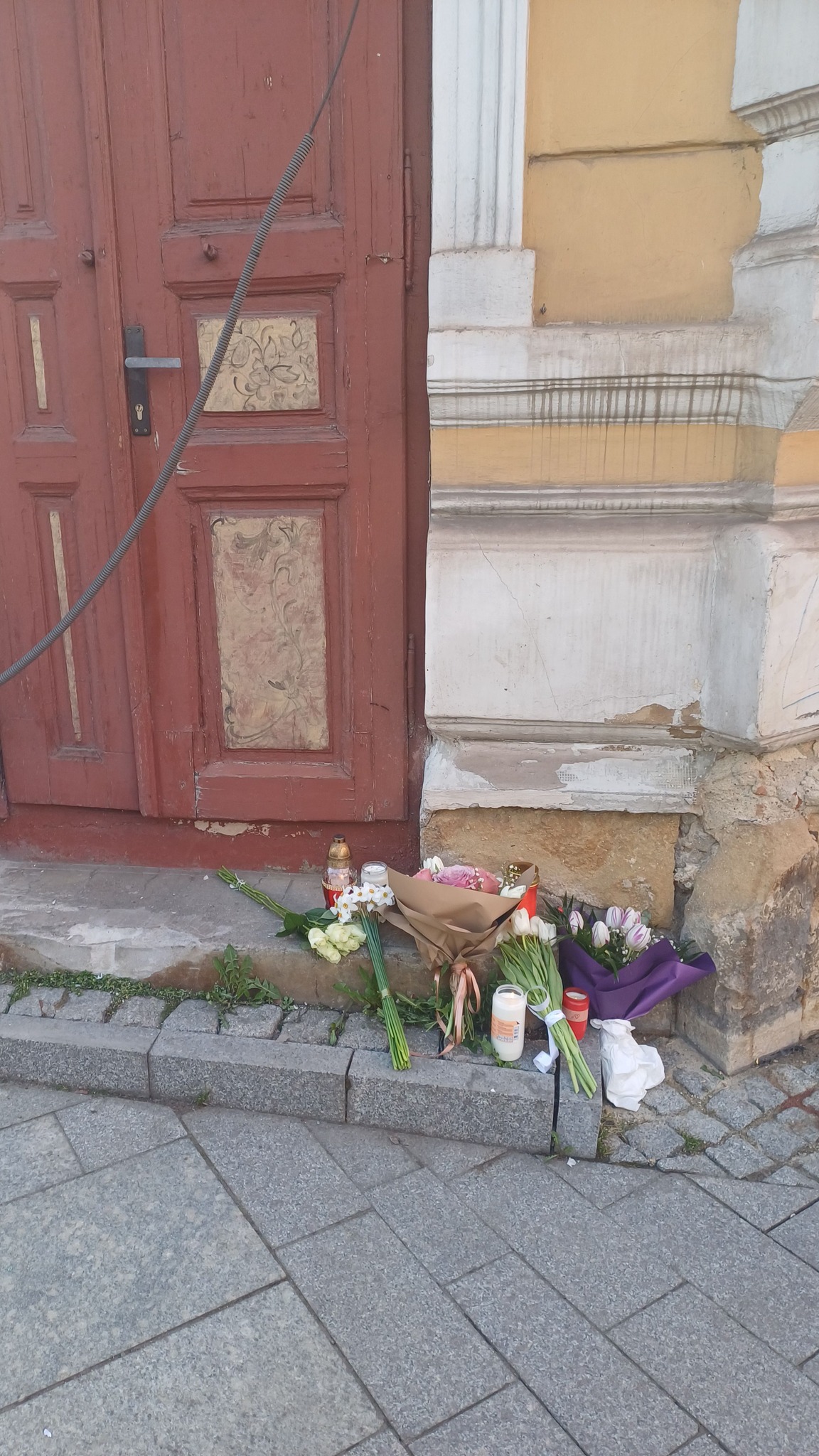 Locul &icirc;n care a murit Aletta, pe trotuar, pe Calea Moților din Cluj, acoperit cu flori și lum&acirc;nări