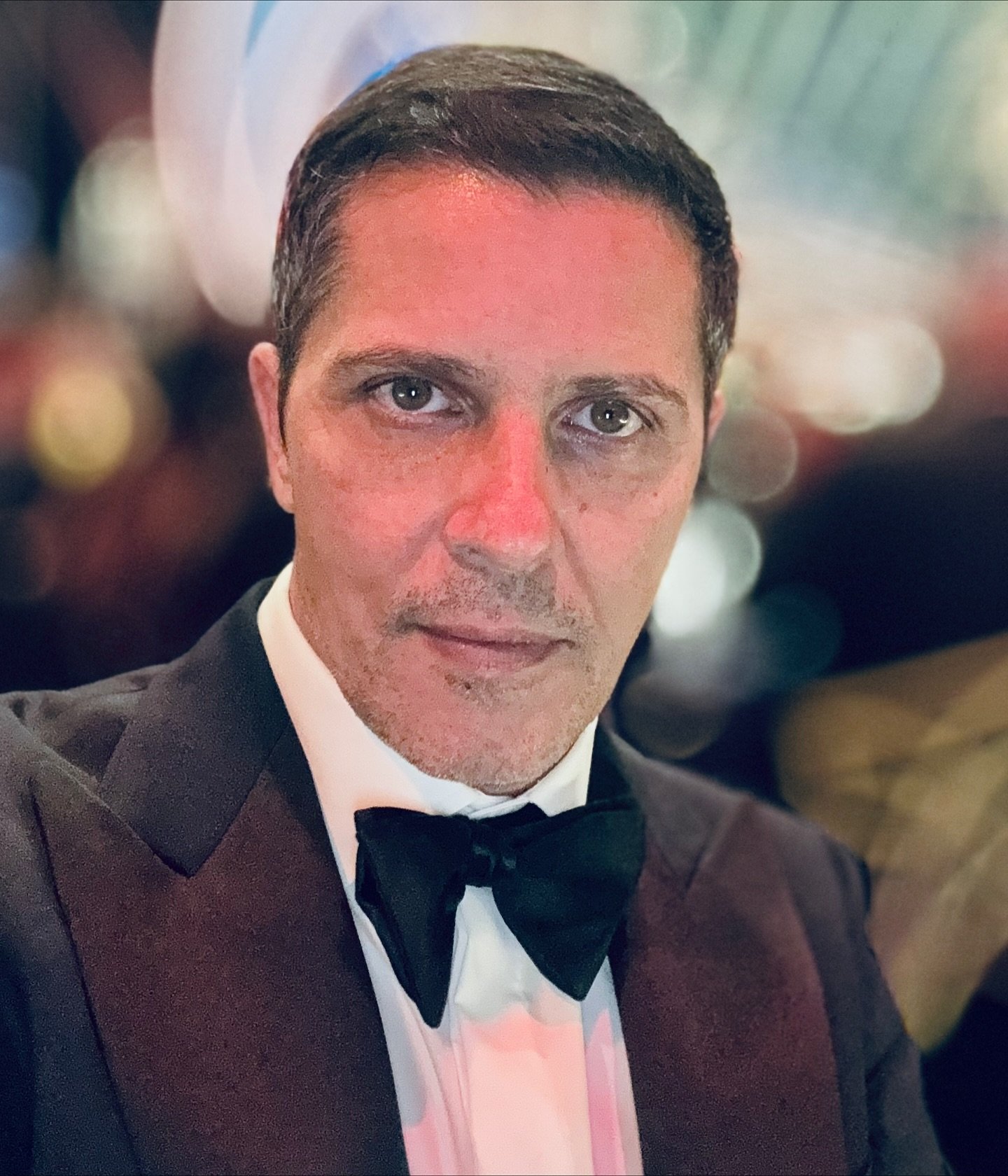 Lucian Viziru făc&acirc;ndu-și un selfie, st&acirc;nd serios, &icirc;n timp ce participa la un eveniment de seară, &icirc;n costum negru elegant, cu cămașă albă și papion negru