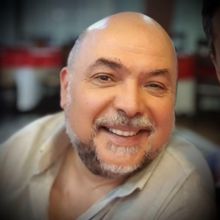 Actorul Constantin Zamfirescu z&acirc;mbitor, &icirc;mbrăcat &icirc;ntr-o cămașă subțire de culoare kaki