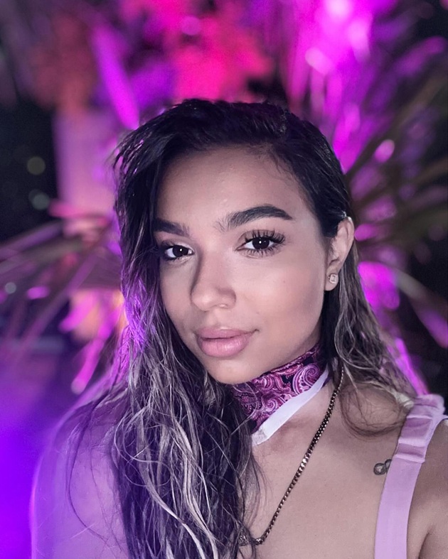 Adriana Simionescu făcându-și un selfie într-o lumină violet, în timp ce afișa un wet look, cu părul dat după ureche
