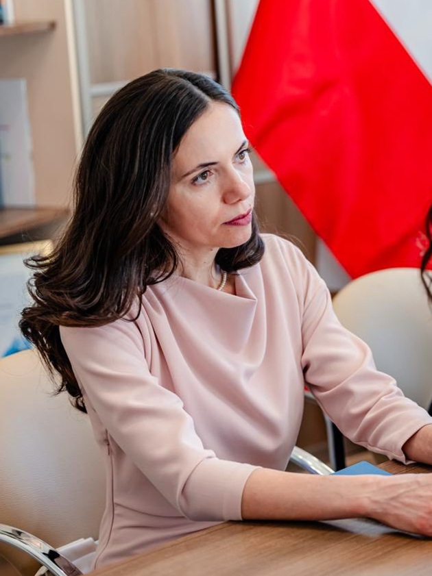 Mirabela Grădinaru, partenera lui Nicușor Dan, &icirc;n timpul unei ședințe, &icirc;mbrăcată &icirc;ntr-o rochie roz deschis, purt&acirc;nd un șirag de perle la g&acirc;t