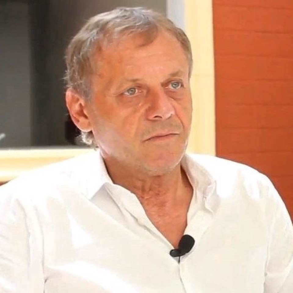 Ilie&nbsp;Balaci st&acirc;nd pe scaun,&nbsp;&icirc;n cămașă albă, cu un microfon de lavalieră agățat de gulerul cămășii