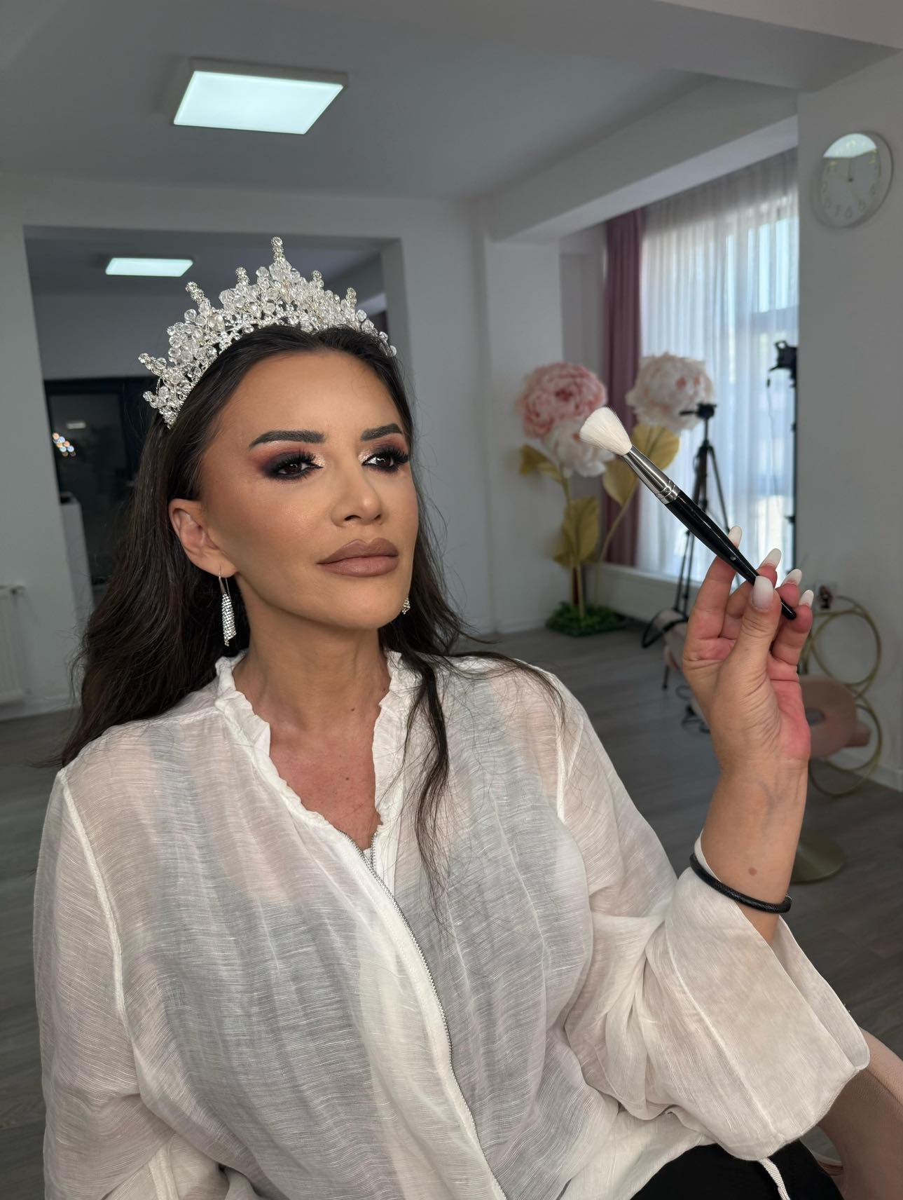 Mara Bănică țin&acirc;nd &icirc;n m&acirc;nă o pensulă de pudră, &icirc;n timp ce se admira &icirc;n oglindă pentru că era machiată profesional și purta o coroană mare pe cap