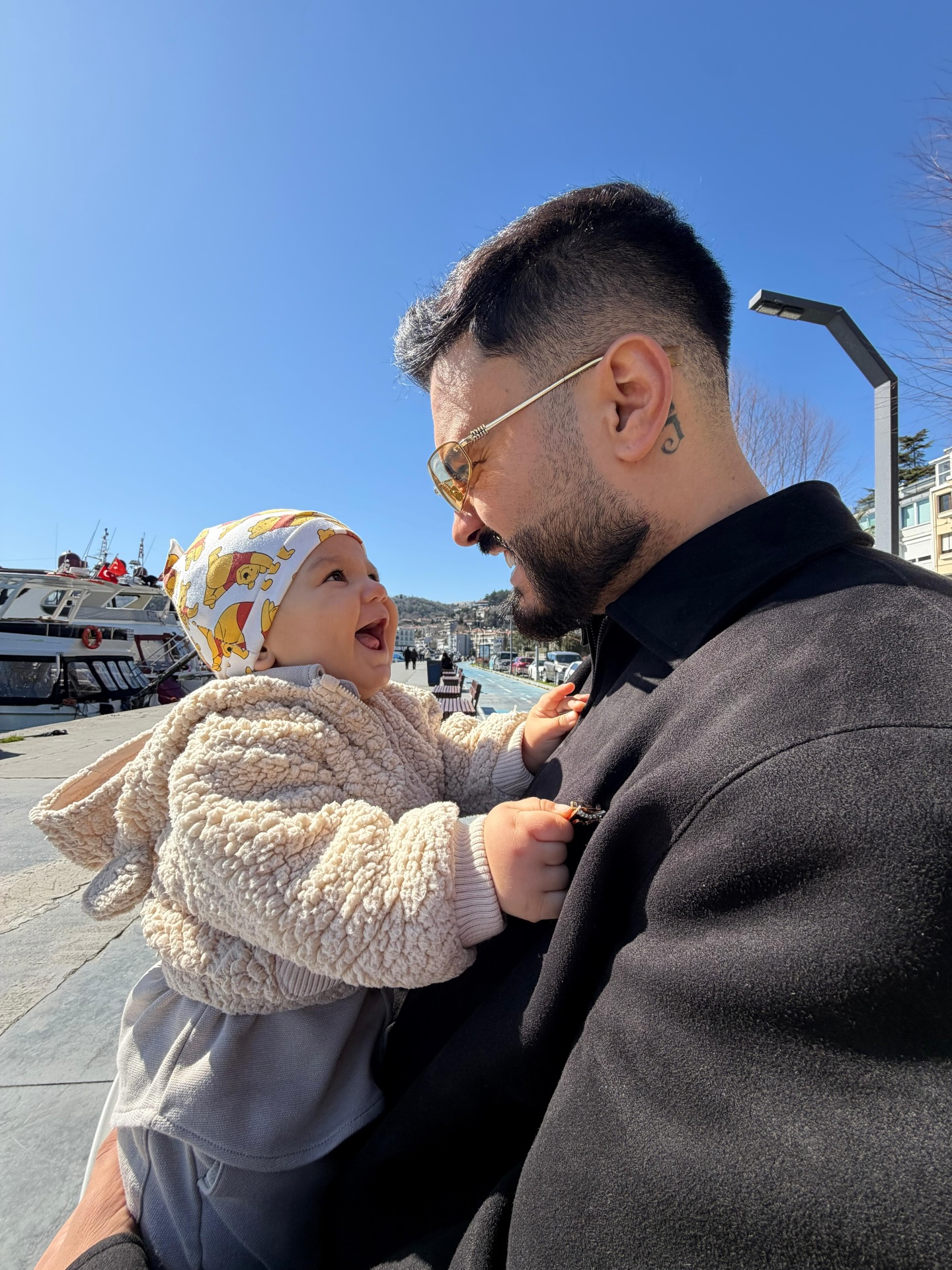 Jador țin&acirc;ndu-l &icirc;n brațe pe fiul său Avraam, &icirc;mbrăcat cu un hanorac din blană, cu căciulă cu ursuleț pe cap