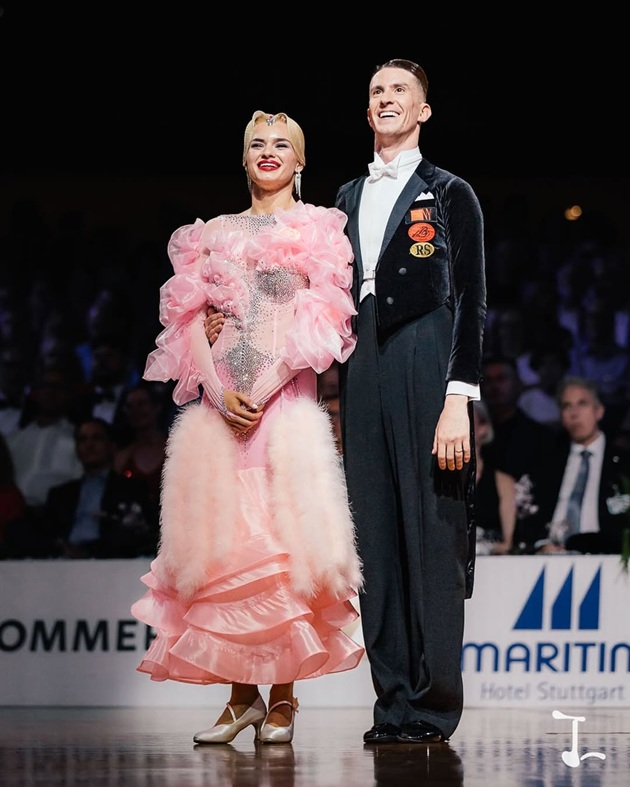 Rareș Popescu țin&acirc;nd-o de mijloc pe Andreea Matei, partenera sa de dans, &icirc;n timpul unei competiții, &icirc;mbrăcați am&acirc;ndoi &icirc;n ținutele elegante de scenă