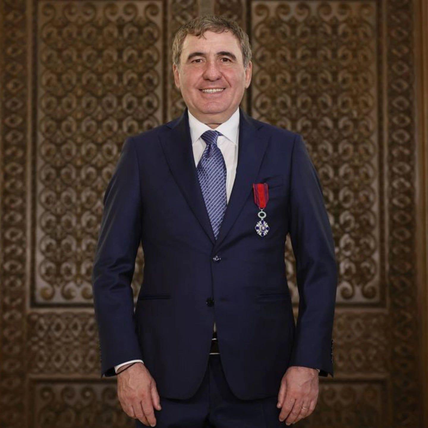 Gheorghe Hagi  z&acirc;mbitor, &icirc;n costum bleumarin, purt&acirc;nd &icirc;n piept meritul &bdquo;Steaua Rom&acirc;niei&rdquo;