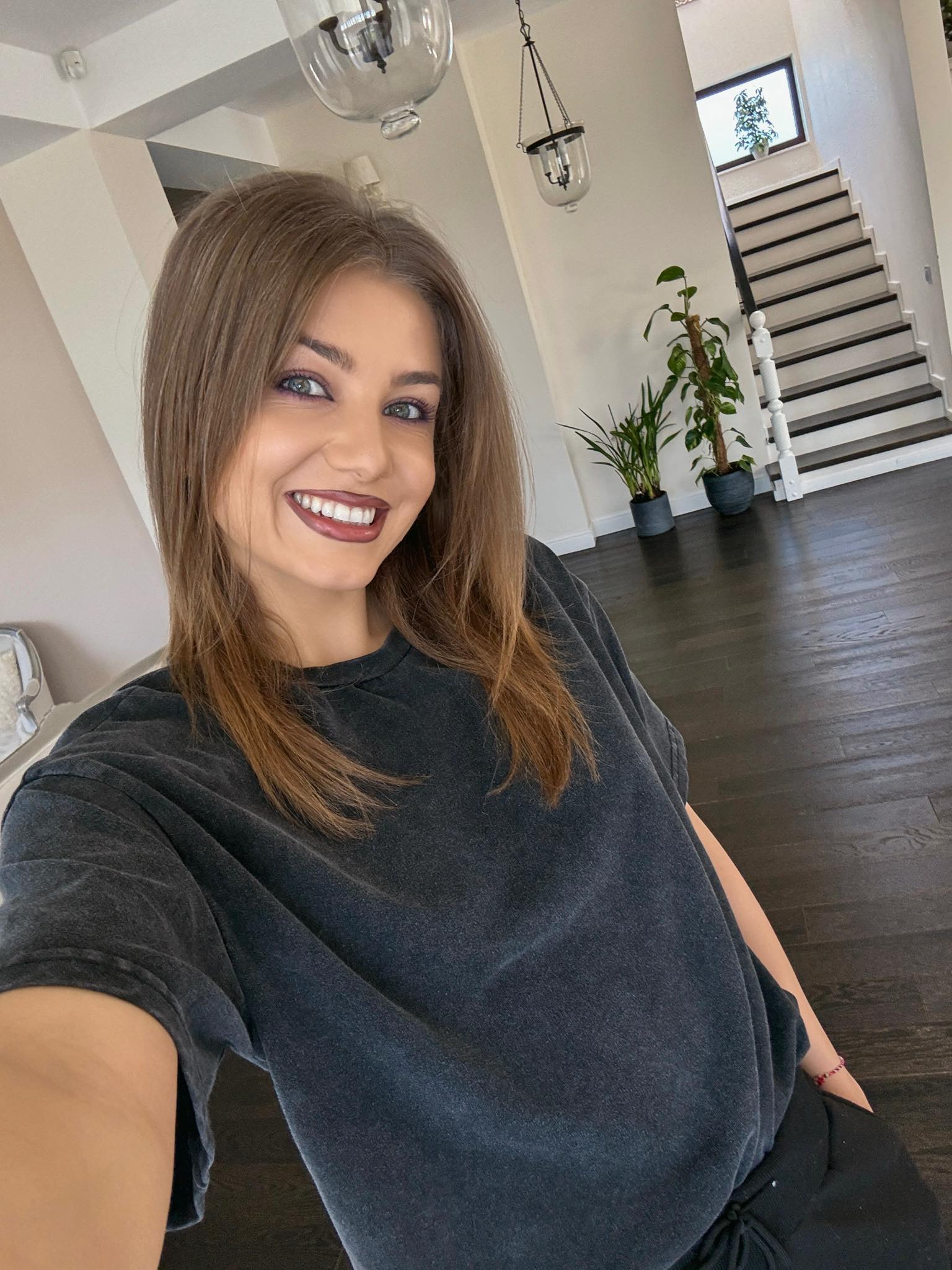 Codruța Filip z&acirc;mbitoare, &icirc;mbrăcată lejer, făc&acirc;ndu-și un selfie &icirc;n casă, &icirc;n timp ce &icirc;n spatele ei se văd scările care duc la etaj