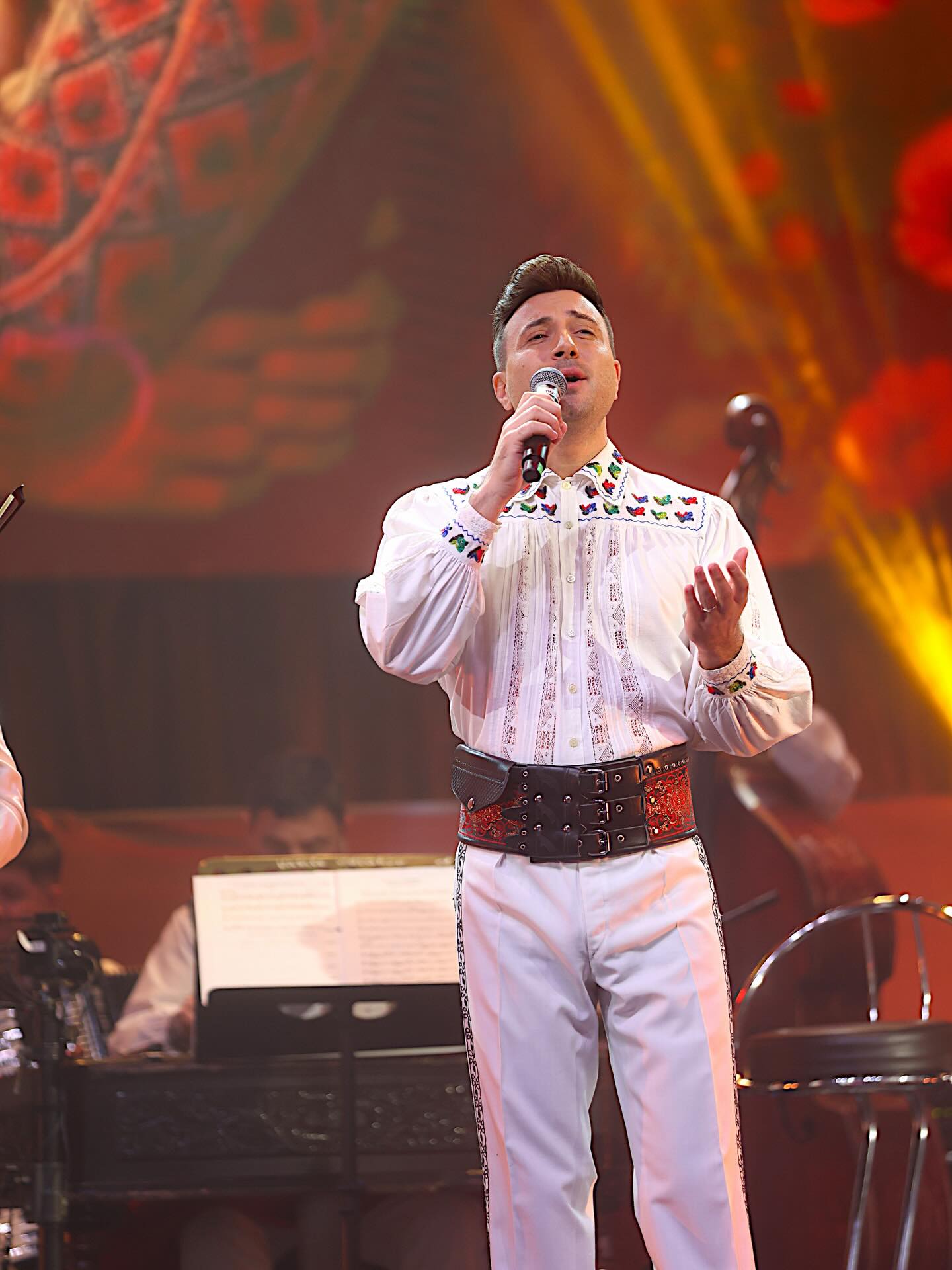 Valentin&nbsp;Sanfira &icirc;n costum popular, pe scenă, c&acirc;nt&acirc;nd &icirc;n fața publicului său